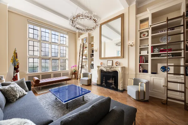 a living room with furniture fireplace and a large window