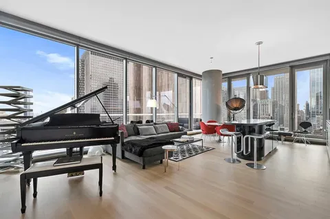 a living room with furniture and floor to ceiling window