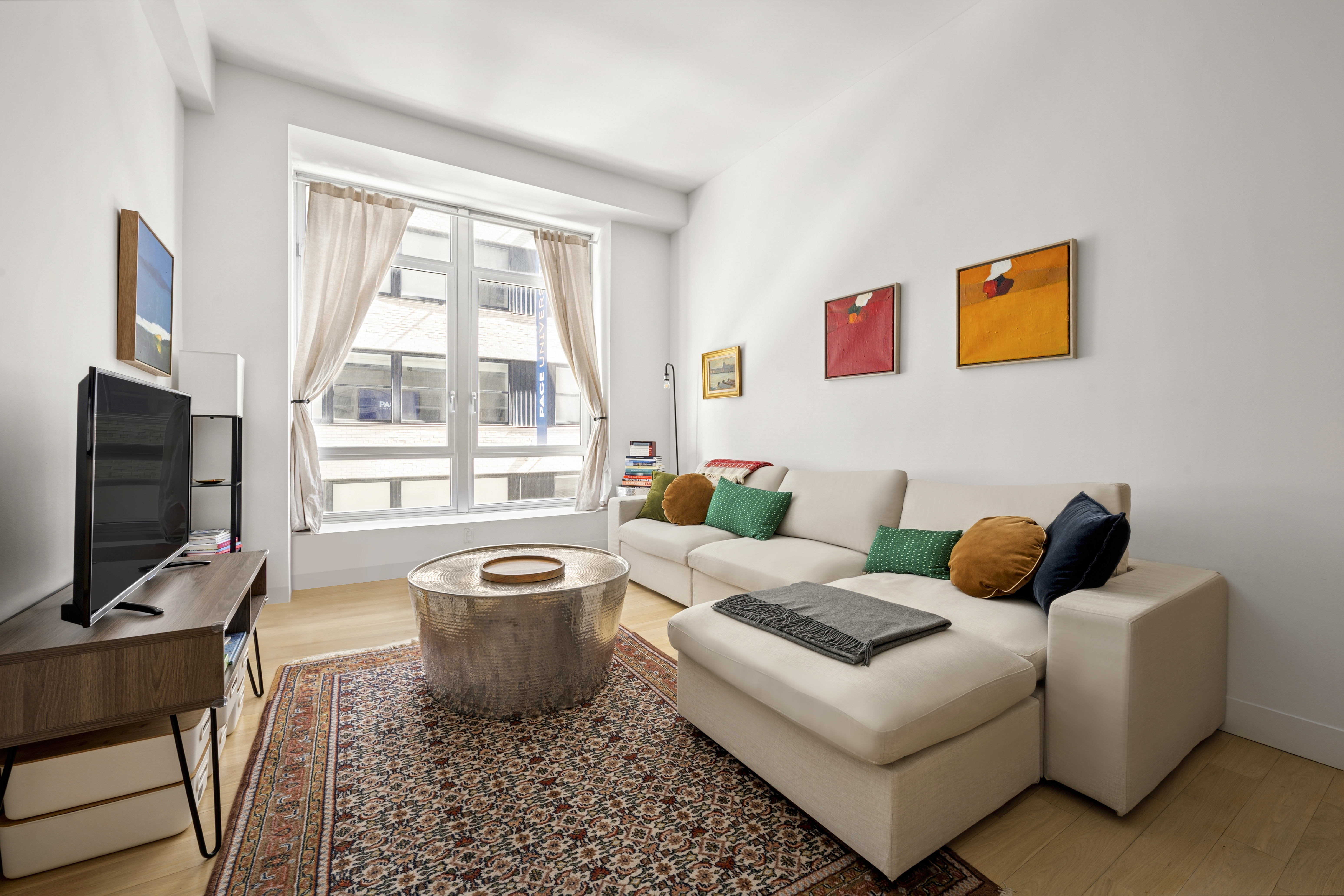 111 Fulton Street, Unit 308 Manhattan, NY 10038 - Photo 3 of 13 a living room with furniture and a flat screen tv
