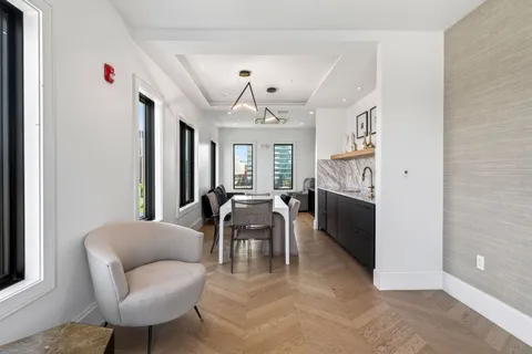a living room with furniture a fireplace and a chandelier