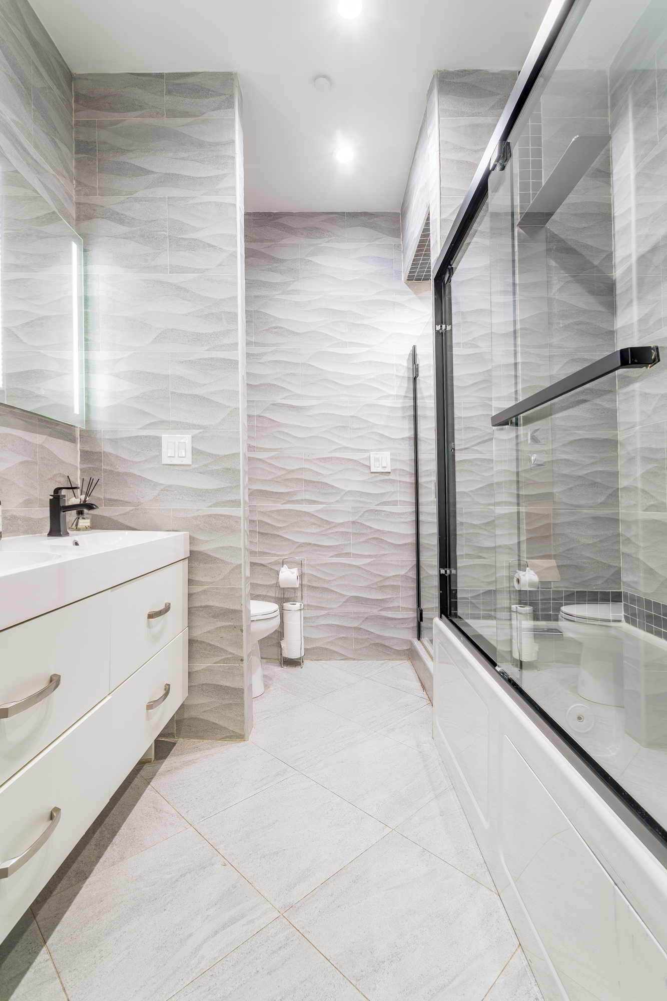616 MacDonough Street, Unit 2 Brooklyn, NY 11233 - Photo 6 of 12 a bathroom with a granite countertop sink mirror and a shower