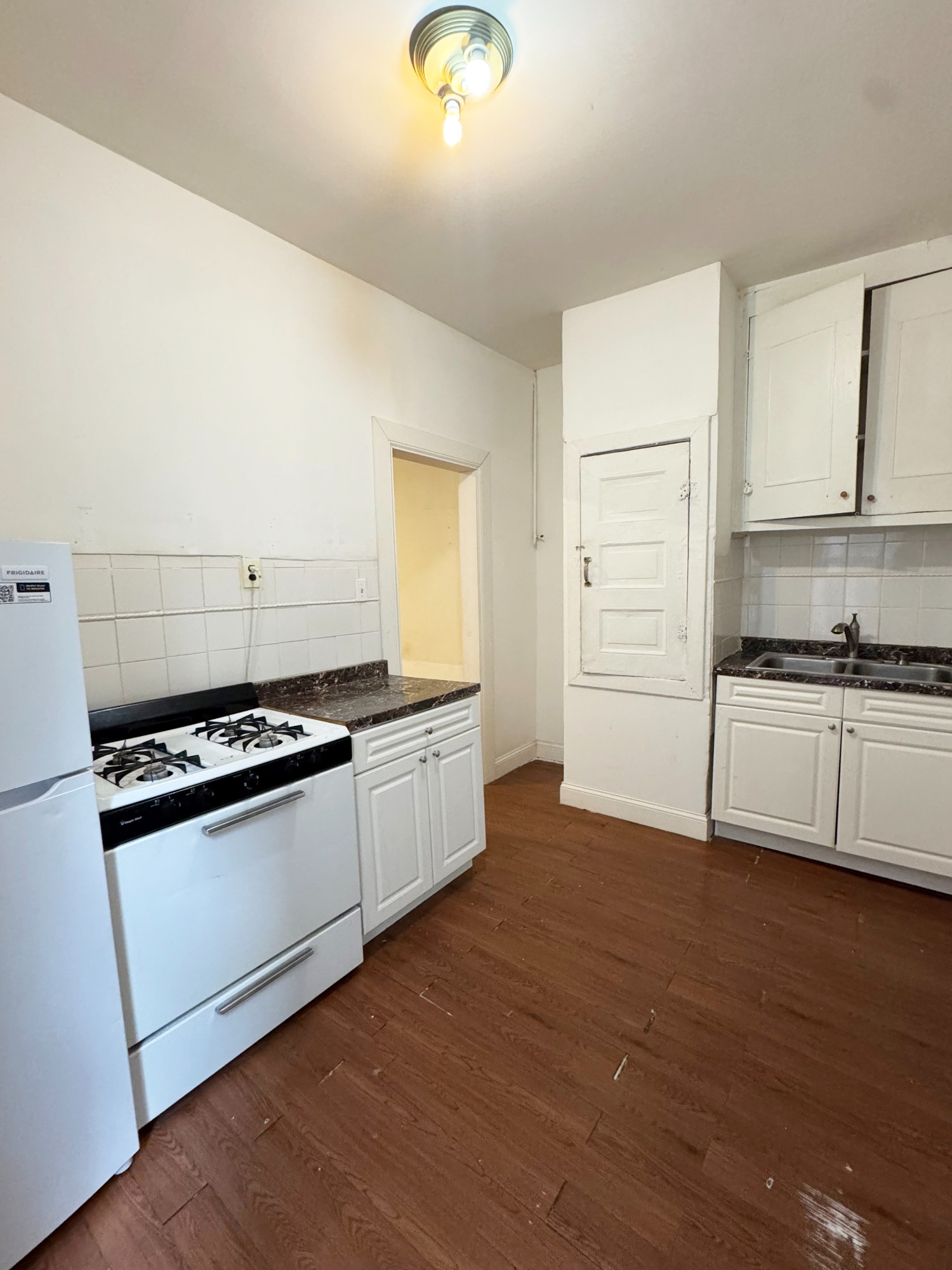 562 7th Street, Unit 3 Brooklyn, NY 11215 - Photo 3 of 6 a kitchen with granite countertop a stove and a refrigerator