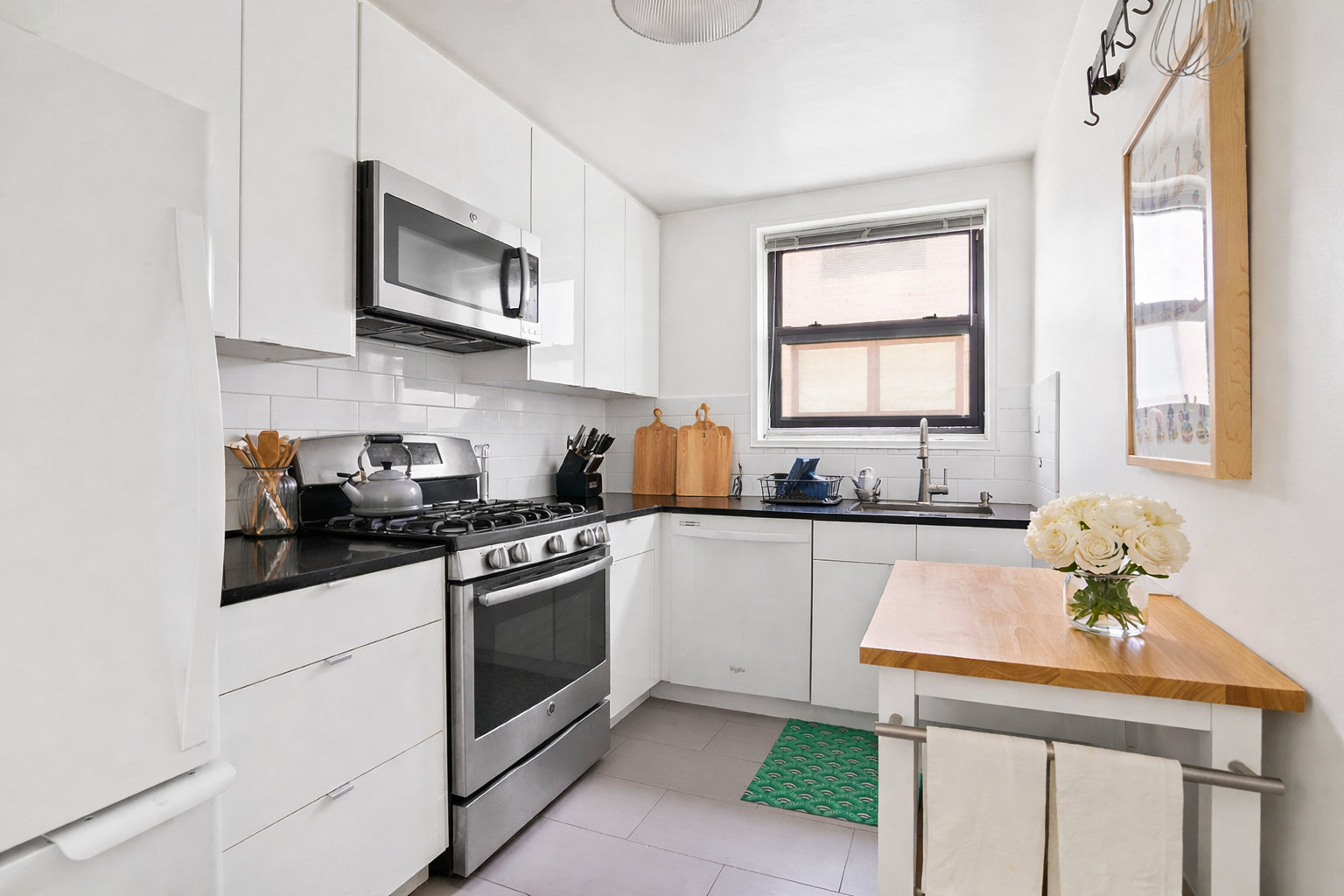 165 Christopher Street, Unit 5Y Manhattan, NY 10014 - Photo 3 of 9 a kitchen with stainless steel appliances a stove sink microwave and cabinets