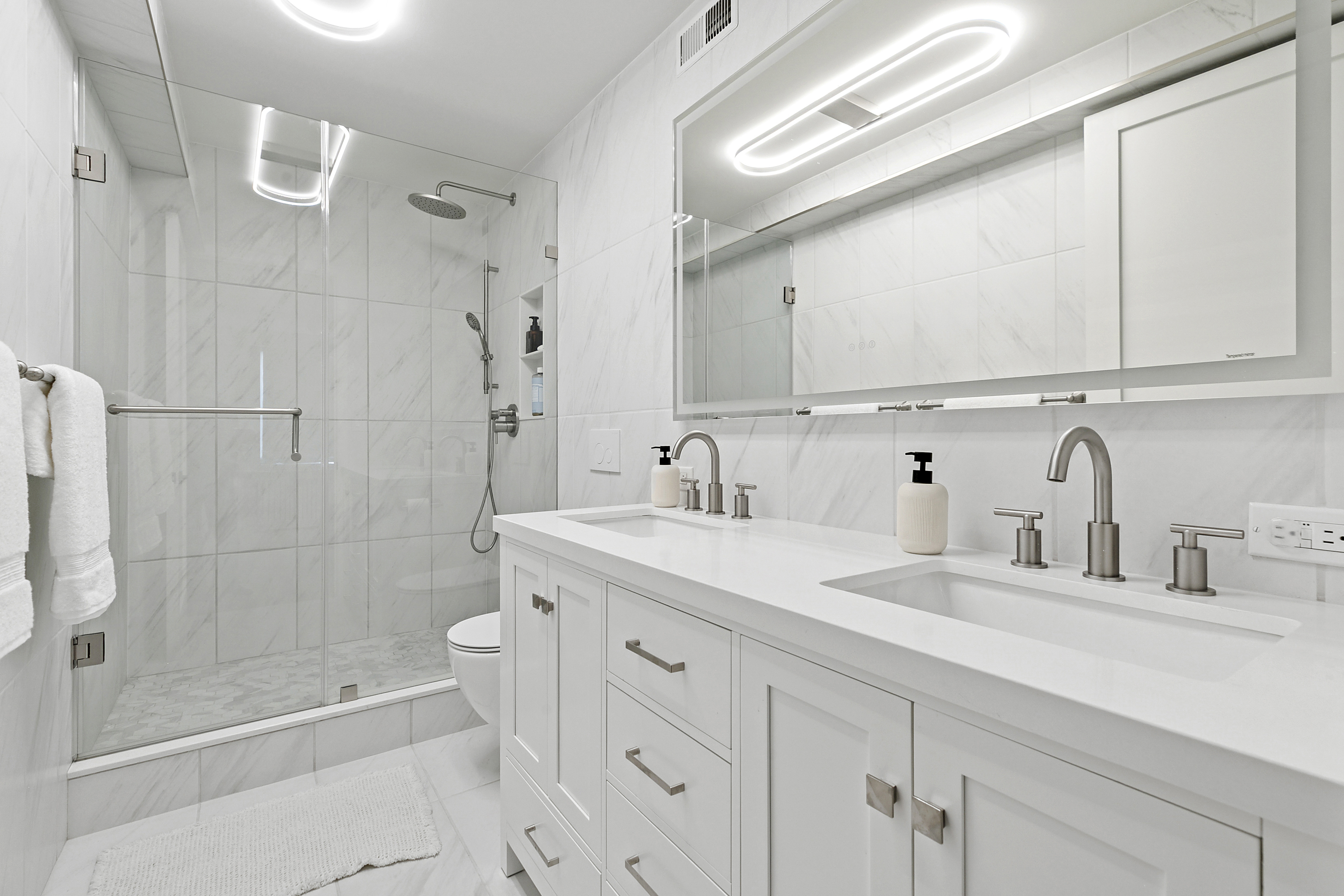 300 East 71st Street, Unit 17DEF Manhattan, NY 10021 - Photo 6 of 16 a bathroom with a shower sink and mirror