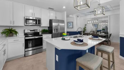 a kitchen with stainless steel appliances a kitchen island a stove a table and chairs in it