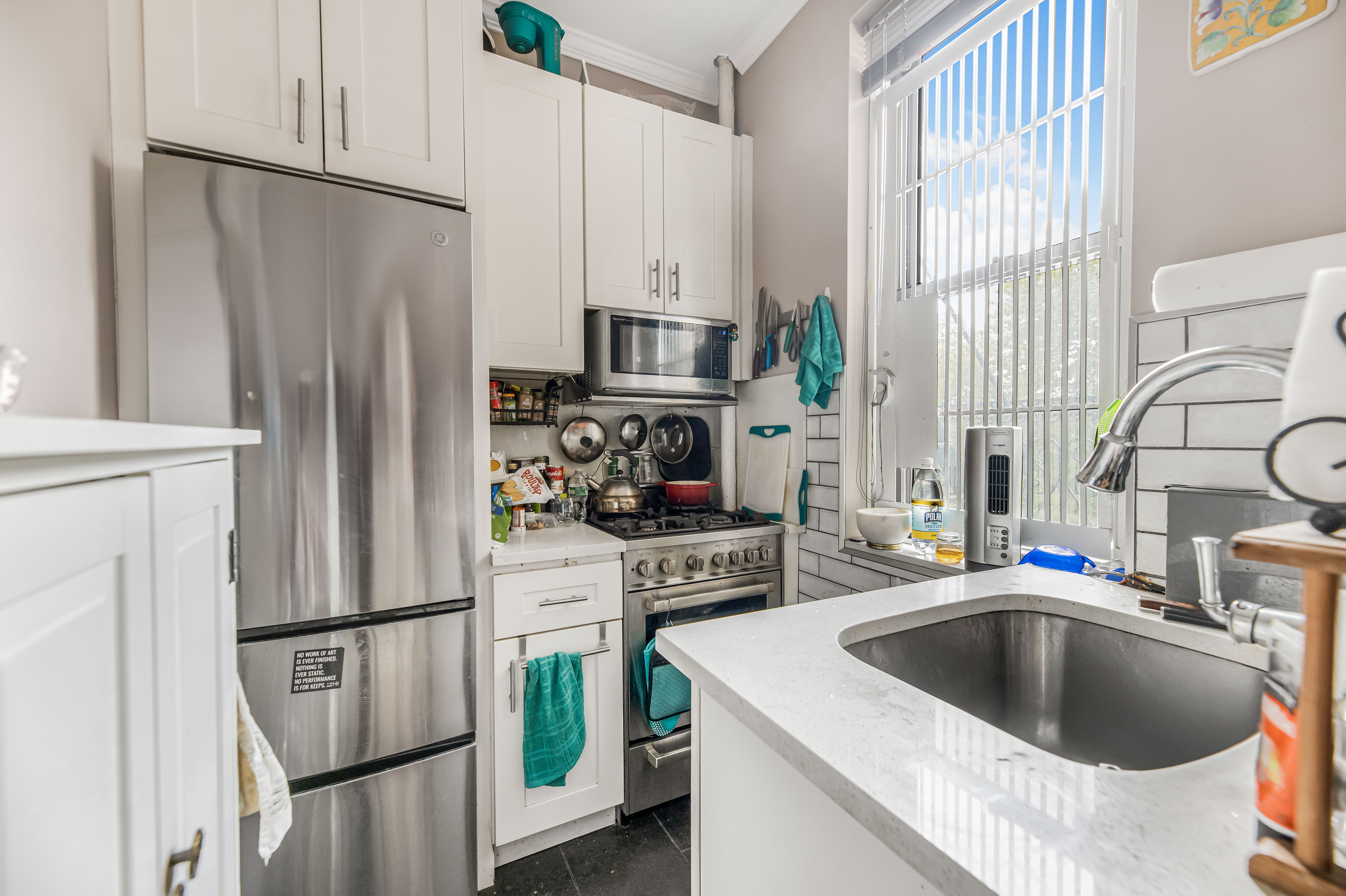 660 Riverside Drive, Unit 4J Manhattan, NY 10031 - Photo 6 of 7 a kitchen with stainless steel appliances a refrigerator a sink a stove and a refrigerator with wooden floor