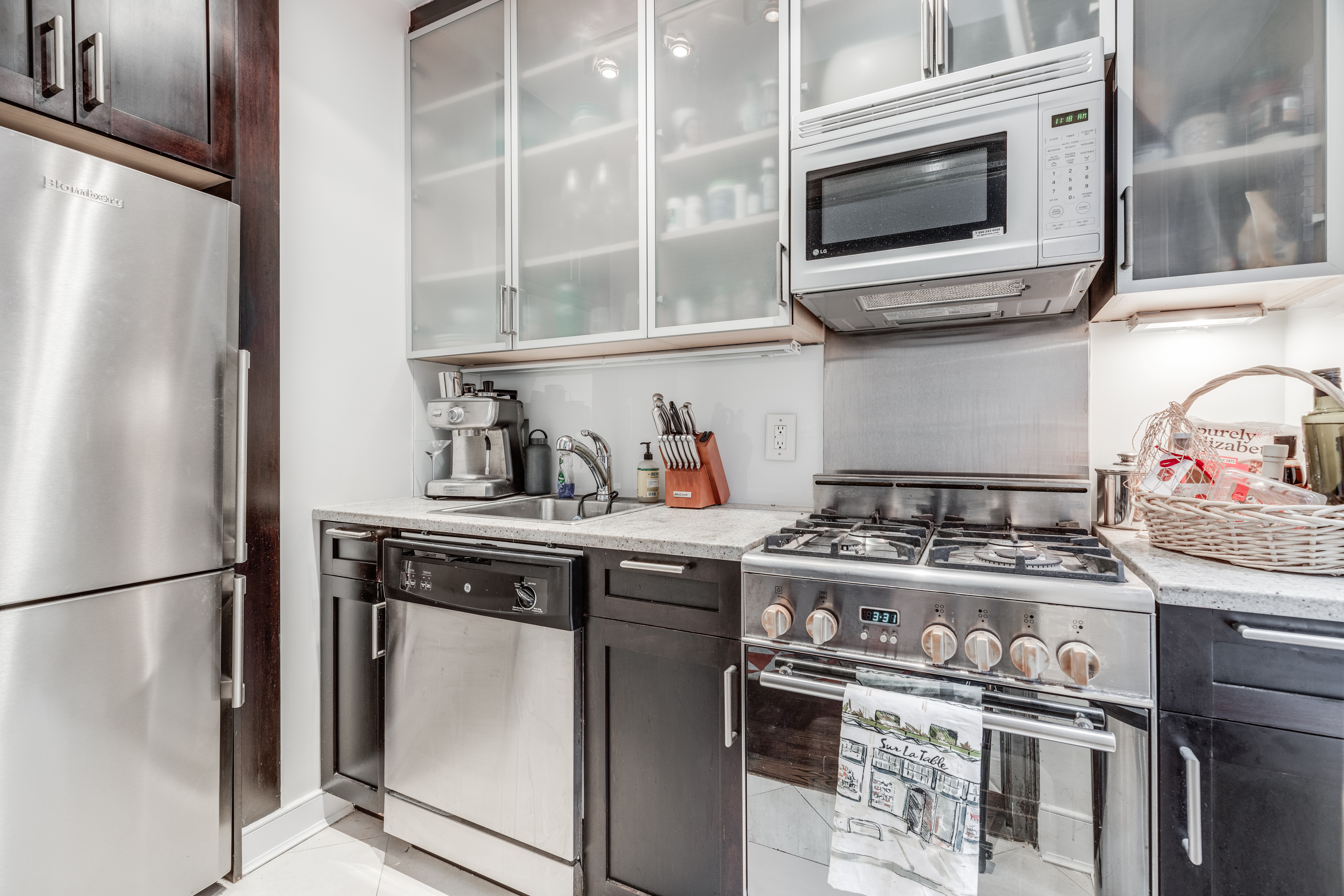 56 7th Avenue, Unit 3G Manhattan, NY 10011 - Photo 3 of 10 a kitchen with stainless steel appliances granite countertop a stove and a refrigerator