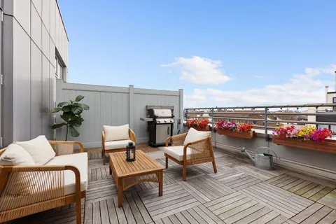 a balcony with wooden floor and outdoor seating