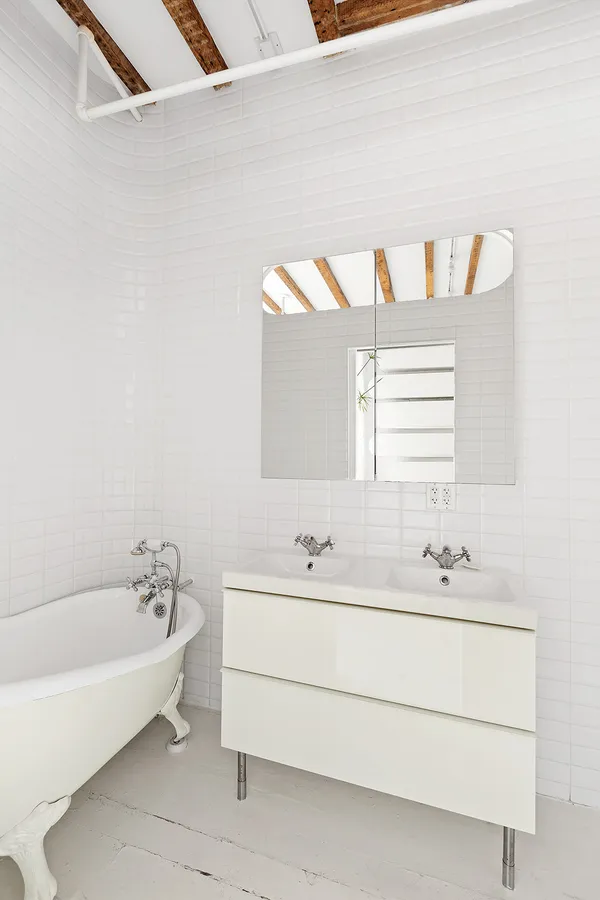 a bathroom with a bathtub a sink and a window