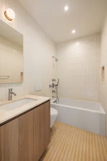 a bathroom with a granite countertop sink a toilet and bathtub