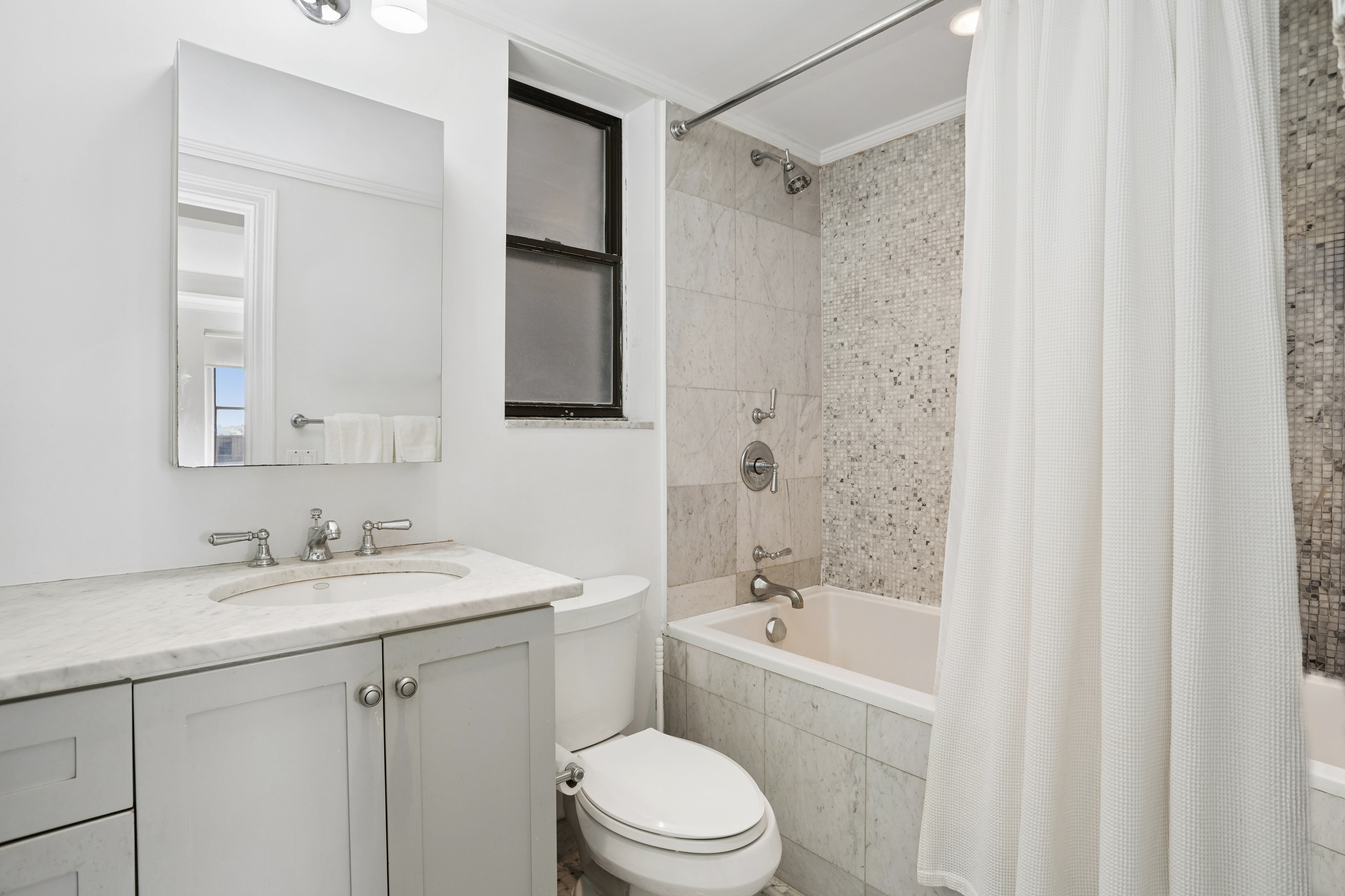 865 1st Avenue, Unit 9C Manhattan, NY 10017 - Photo 8 of 13 a bathroom with a sink a toilet and shower