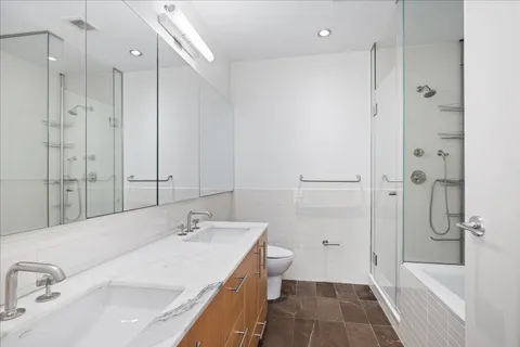 a bathroom with a tub sink shower and a mirror