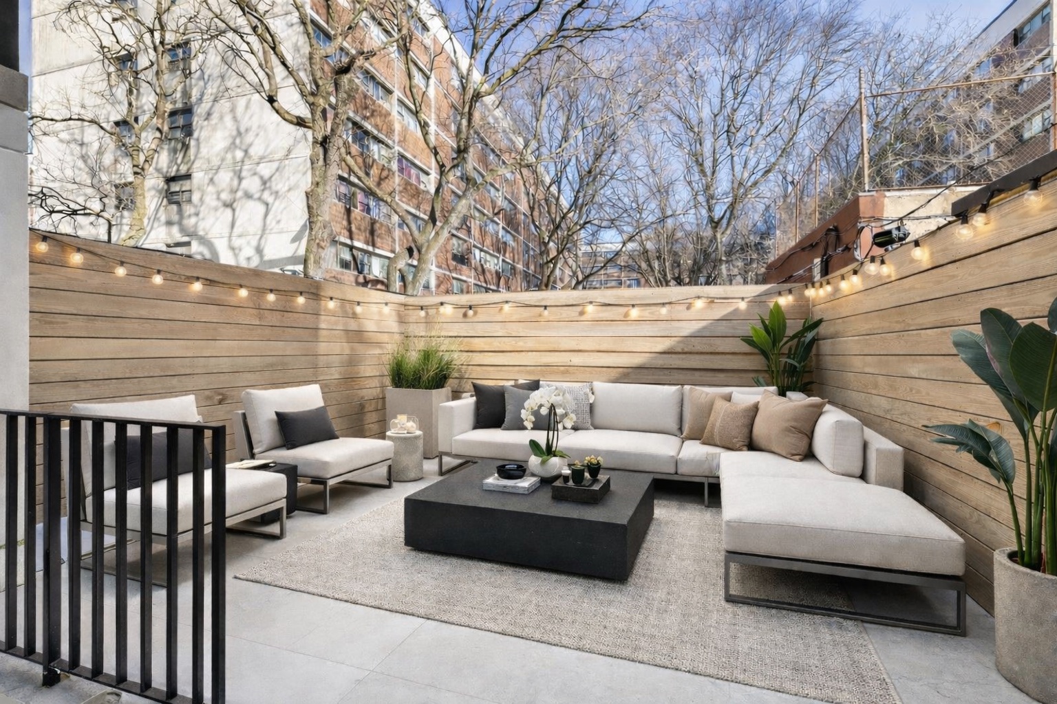 a view of a patio with couches and a table and chairs with wooden floor and fence