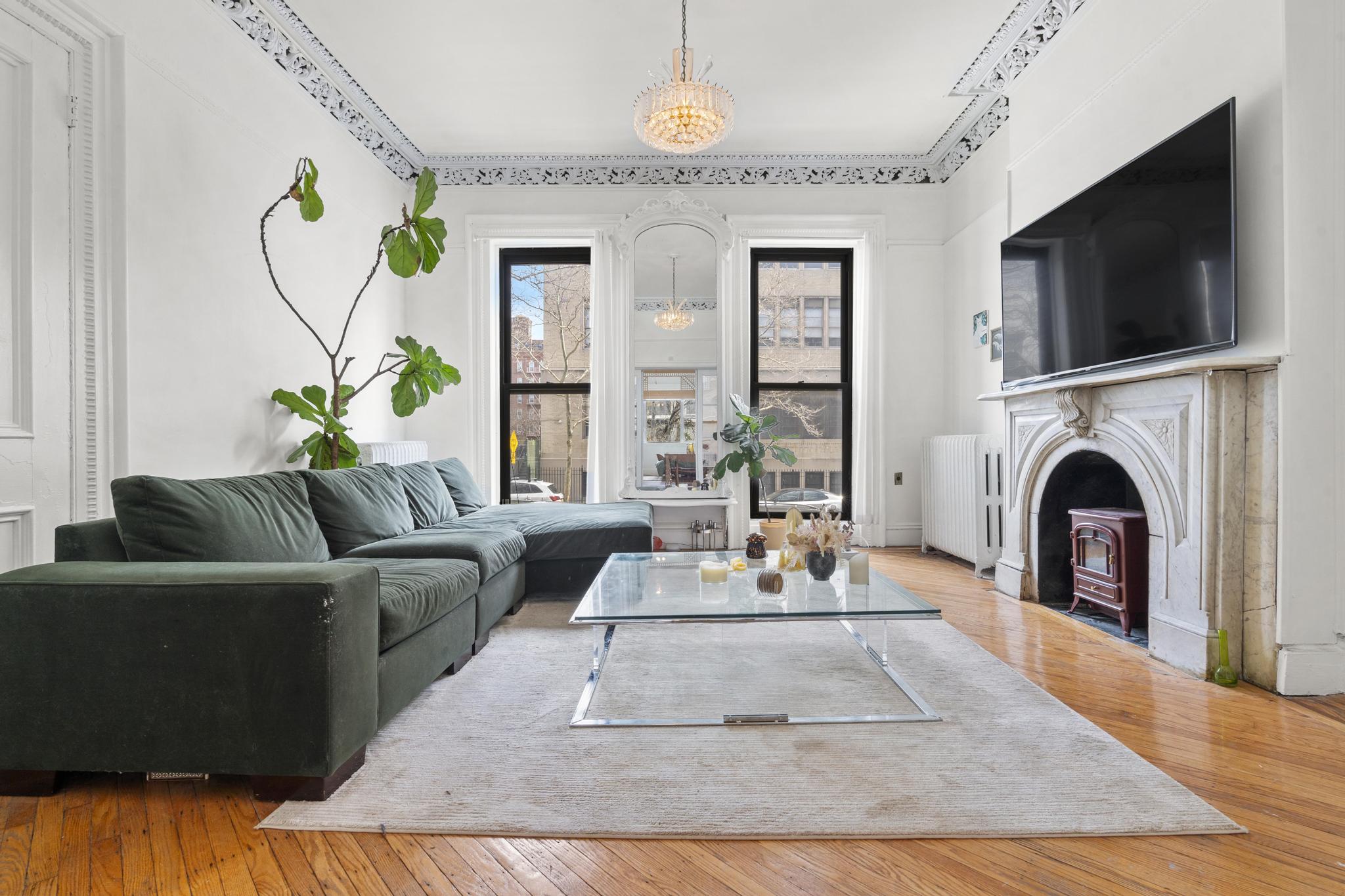 364 Clermont Avenue Brooklyn, NY 11238 - Photo 2 of 18 a living room with furniture a flat screen tv and a fireplace
