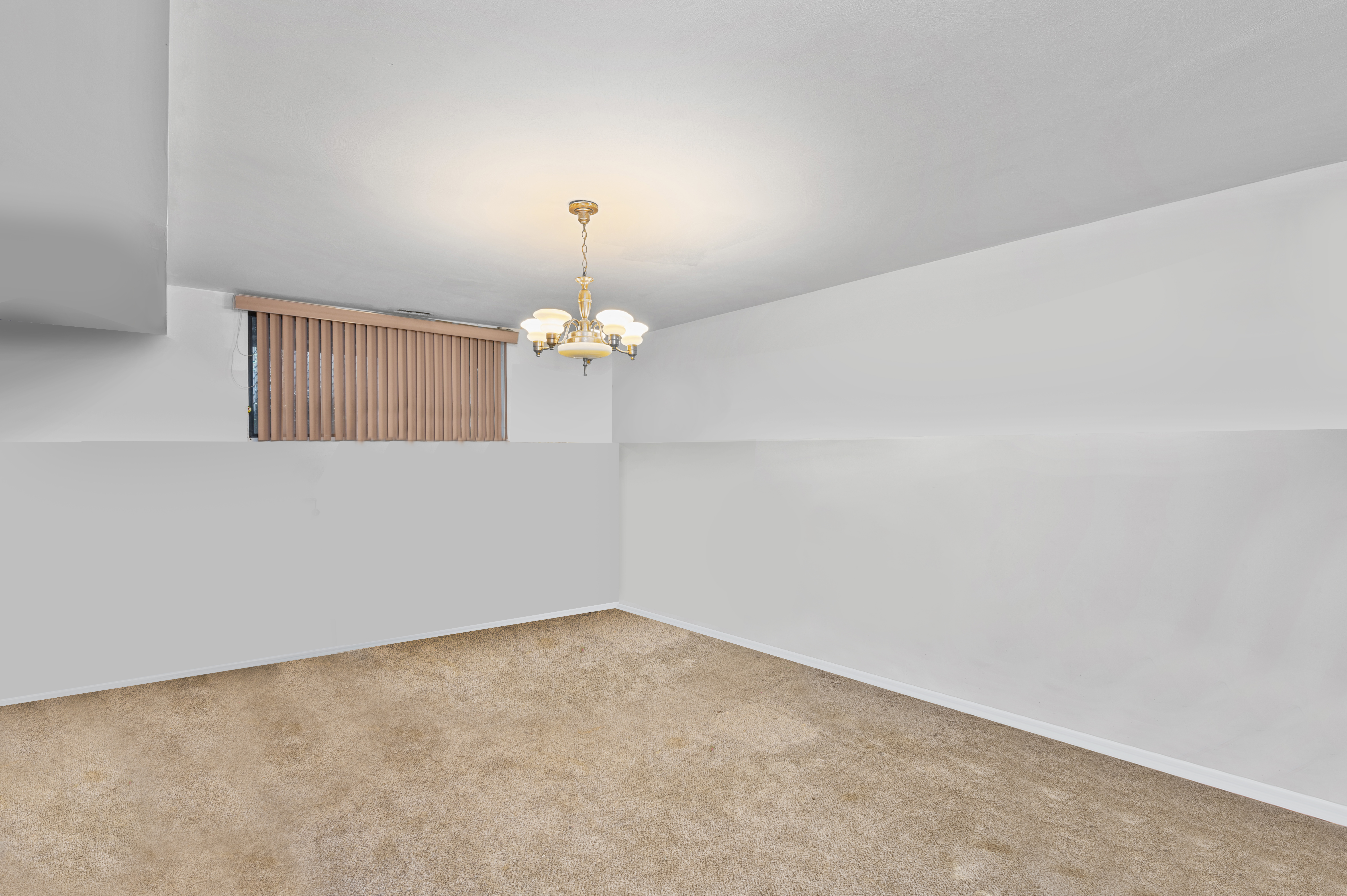 20 Eric Lane Staten Island, NY 10308 - Photo 14 of 20 an empty room with a chandelier fan and wooden floor