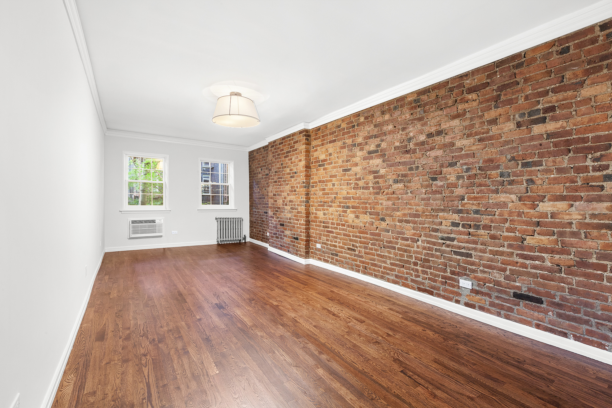 522 East 82nd Street, Unit 1 Manhattan, NY 10028 - Photo 9 of 16 a view of empty room with wooden floor and fan