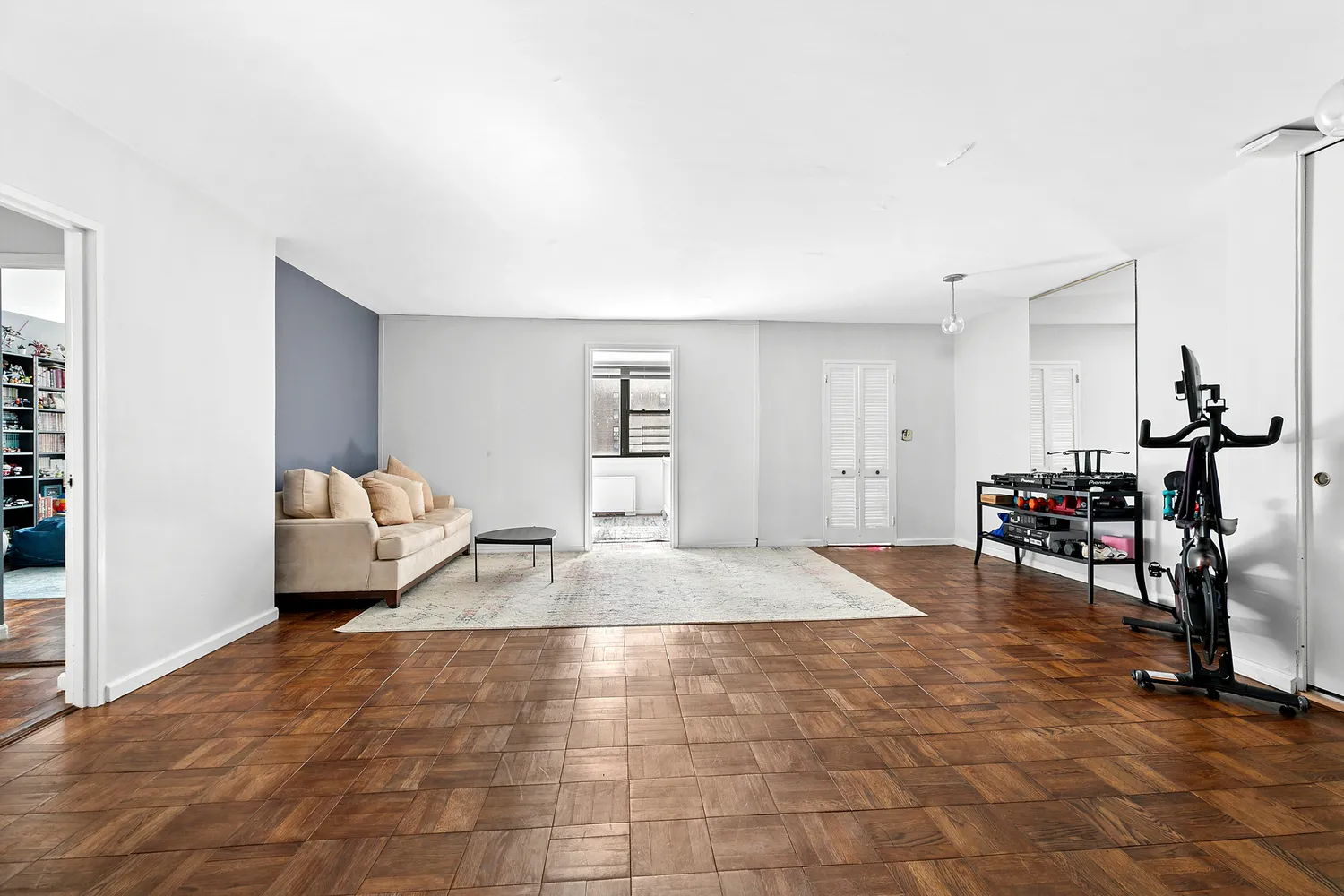 a living room with furniture and a gym equipment