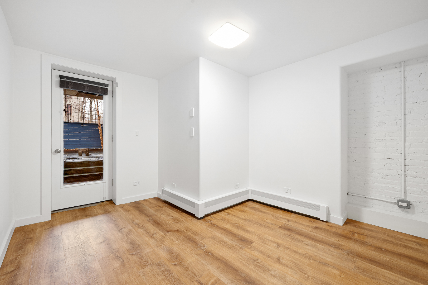 63 Putnam Avenue Brooklyn, NY 11238 - Photo 5 of 11 an empty room with wooden floor and windows