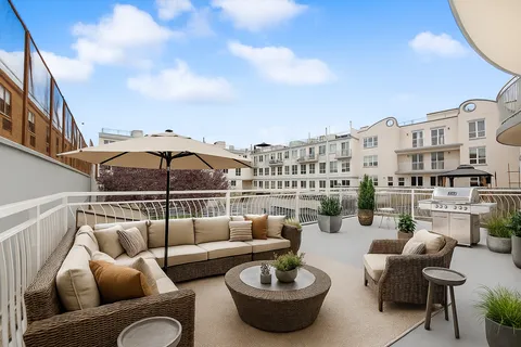 a view of a roof deck with couches and potted plants
