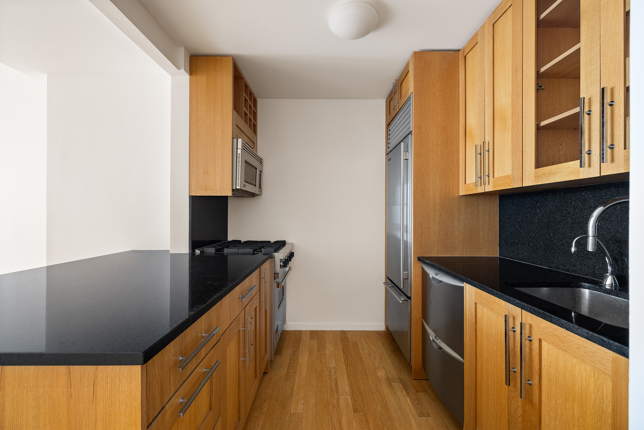 88 Greenwich Street, Unit 1014 Manhattan, NY 10006 - Photo 2 of 14 a kitchen with granite countertop a sink a stove and refrigerator