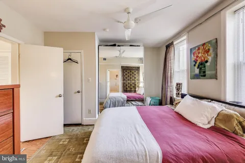 a bedroom with a bed and a painting on the wall