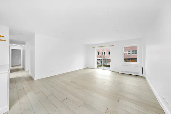 a view of a hallway with wooden floor and a cabinet