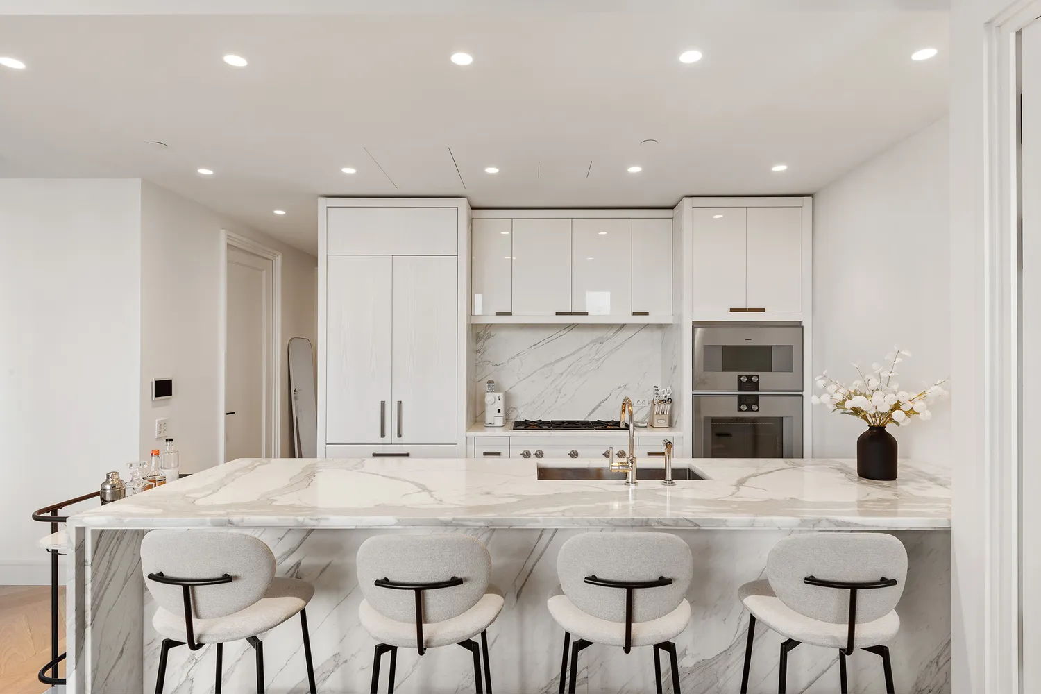 a kitchen with stainless steel appliances kitchen island granite countertop a kitchen island and chairs in it