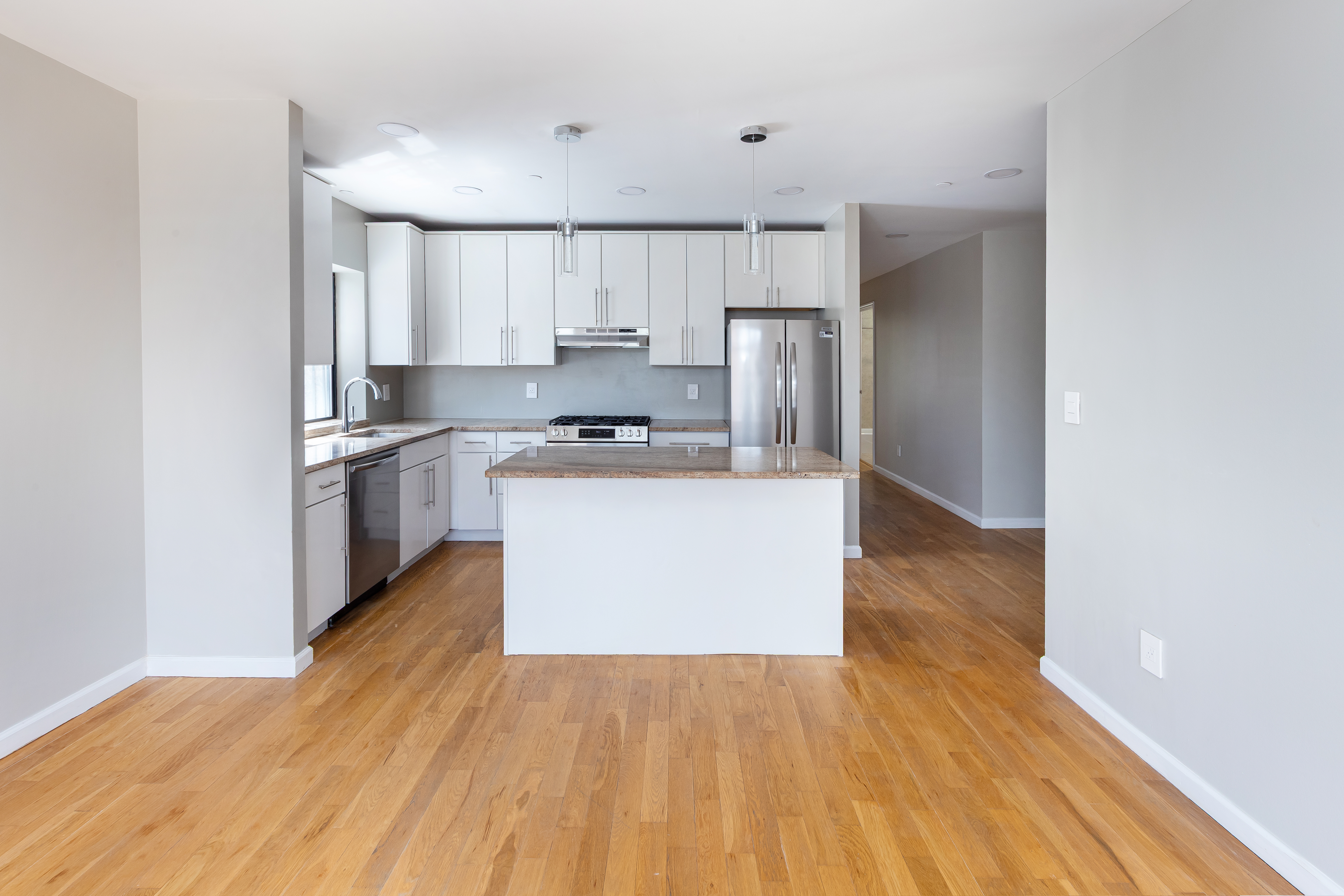 416 East 117th Street, Unit 5A Manhattan, NY 10035 - Photo 4 of 16 a kitchen with wooden floors and white cabinets