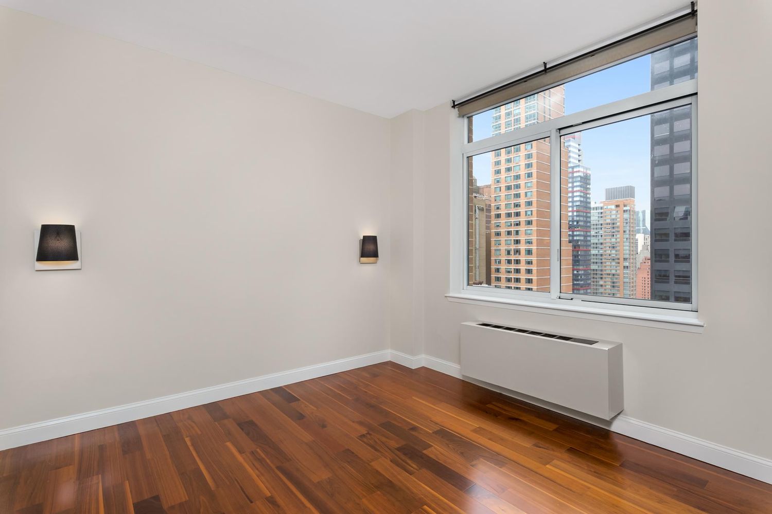 212 East 57th Street, Unit 18A Manhattan, NY 10022 - Photo 8 of 14 an empty room with wooden floor and windows