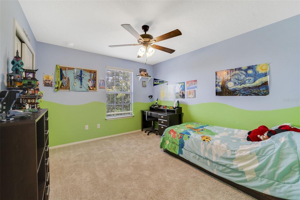 352 Giovani Boulevard Clermont, FL 34715 - Photo 32 of 46 a bedroom with a bed and a chandelier