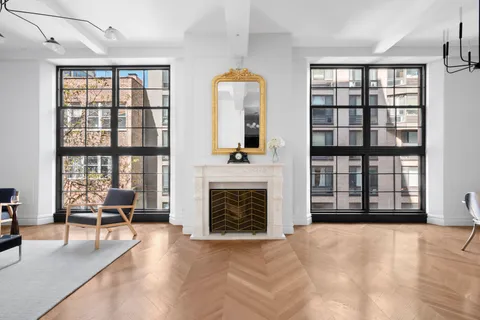 wooden floor fireplace and windows in an empty room