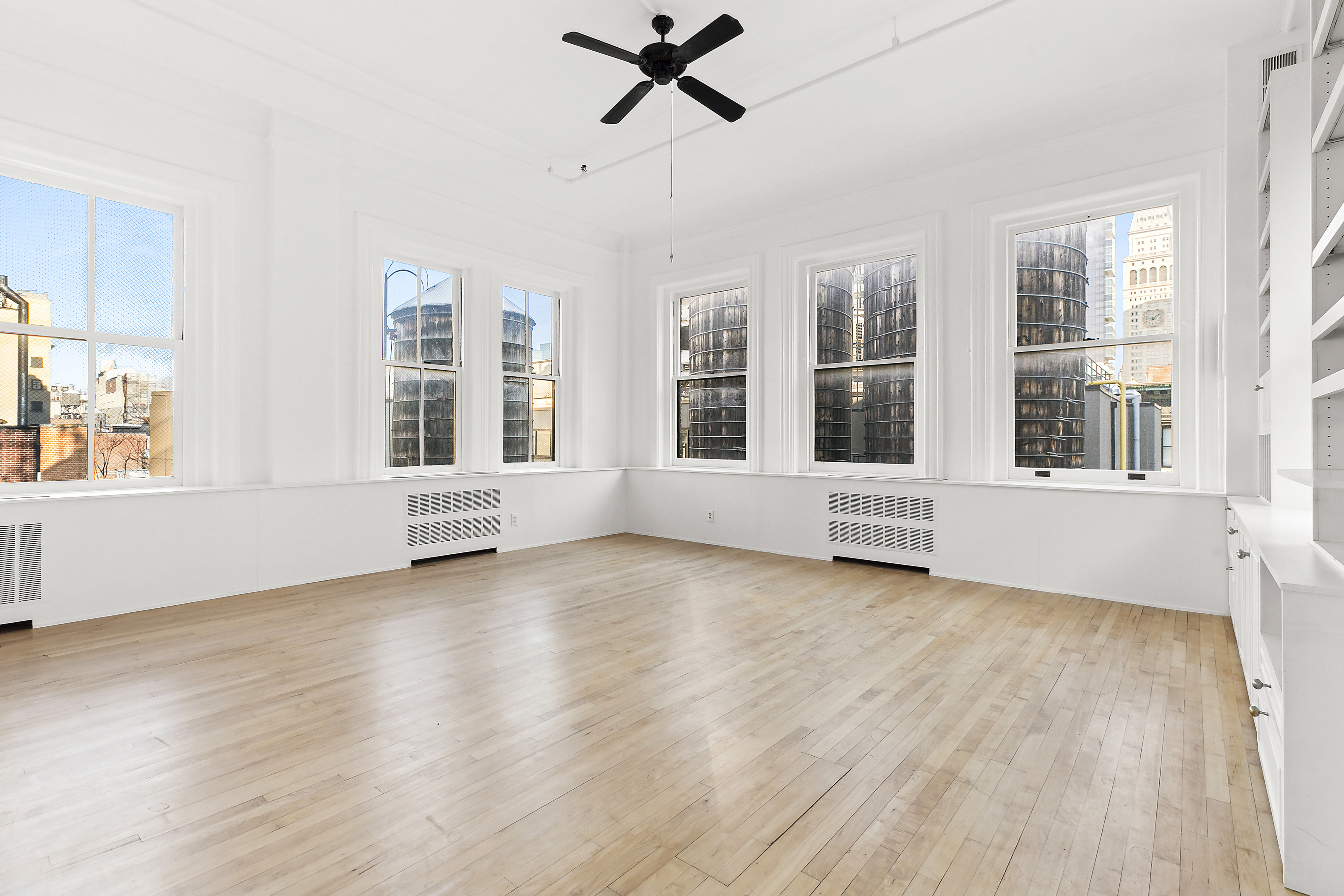 874 Broadway, Unit 907 Manhattan, NY 10003 - Photo 12 of 14 a view of an empty room with wooden floor and windows