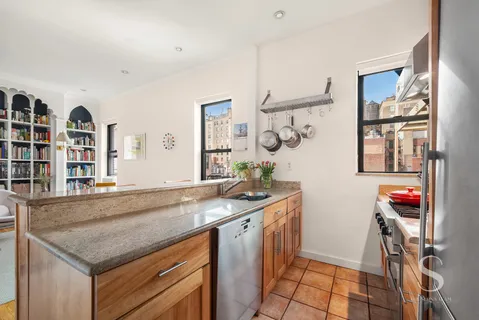 a utility room with stainless steel appliances granite countertop a sink and a window