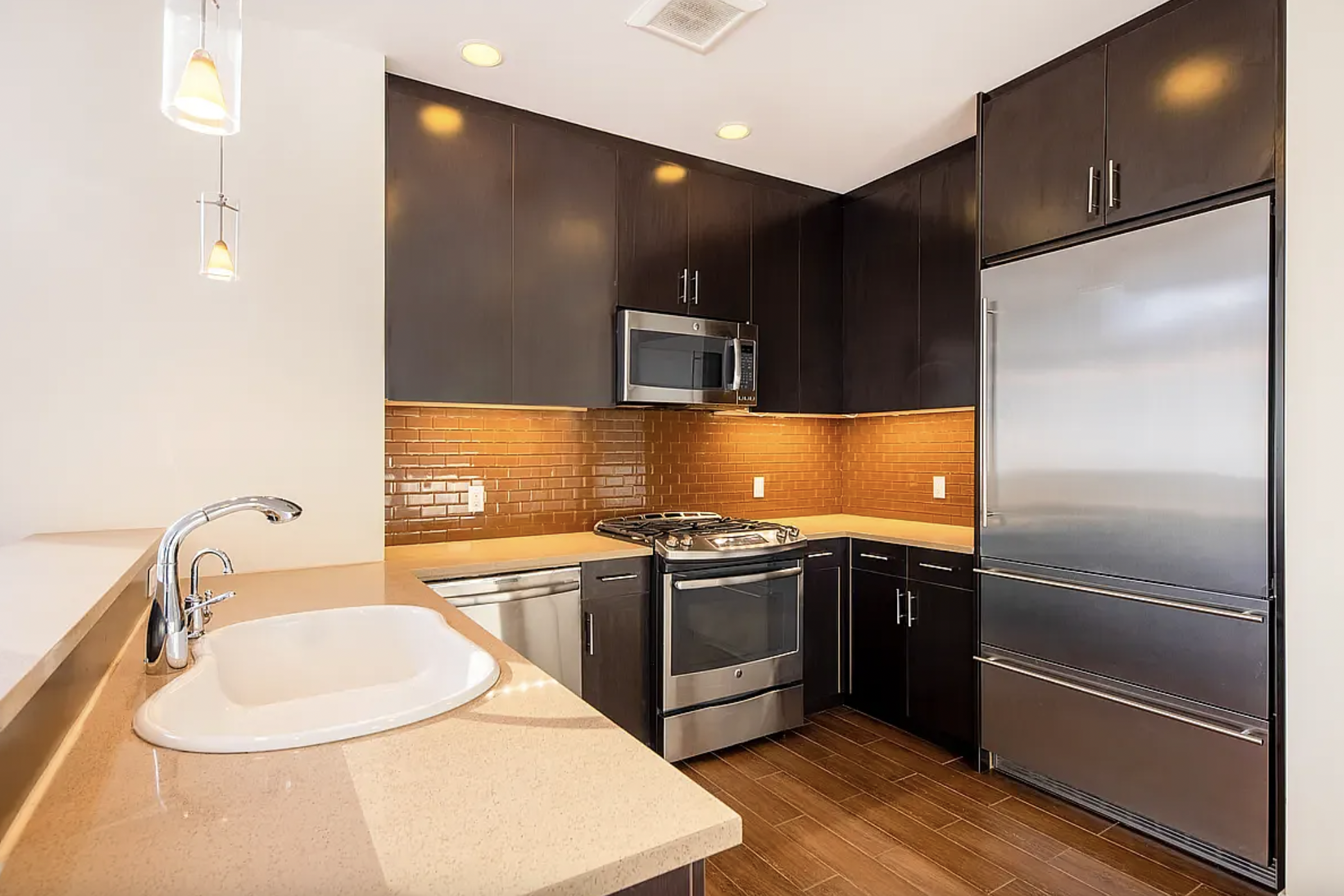 42-37 27th Street, Unit 8C Queens, NY 11101 - Photo 2 of 11 a kitchen with stainless steel appliances granite countertop a sink and a refrigerator