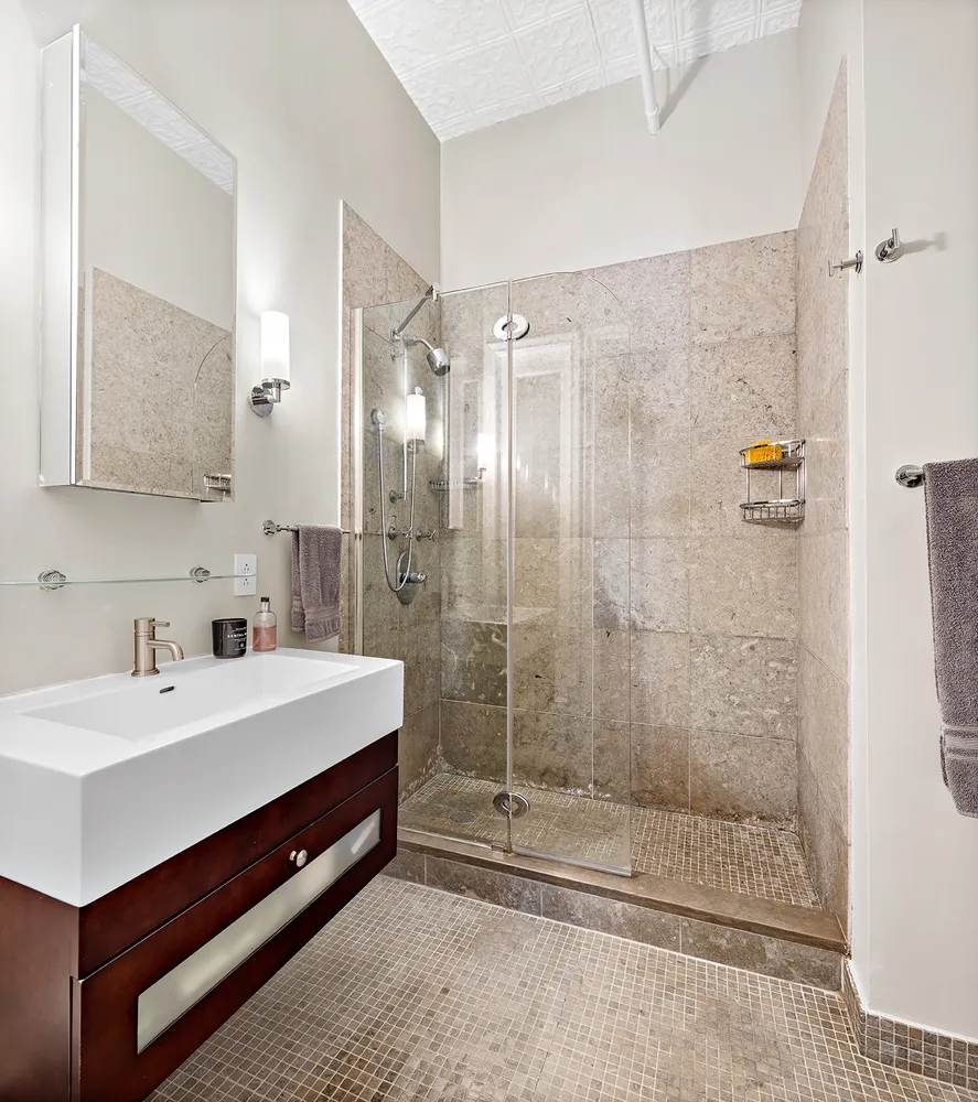a bathroom with a double vanity sink mirror and shower