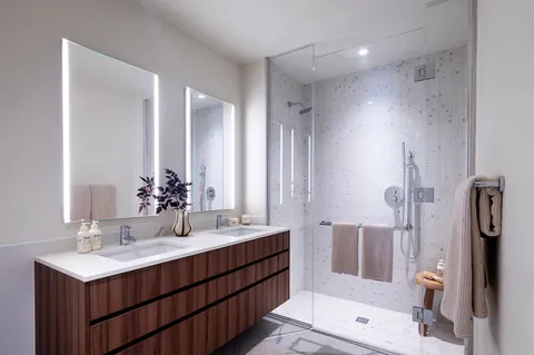 a bathroom with a double vanity sink mirror double and shower