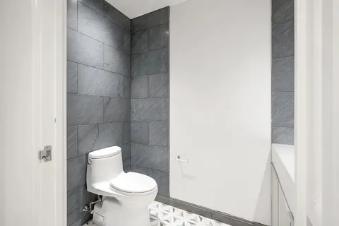 a white toilet sitting next to a white sink and a vanity
