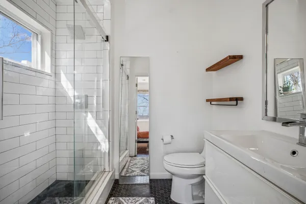 a bathroom with a sink a toilet and shower