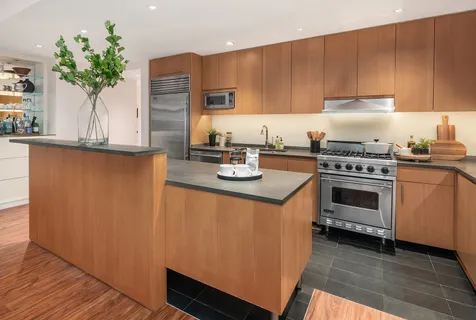 a kitchen with granite countertop a stove a sink dishwasher and white cabinets with wooden floor