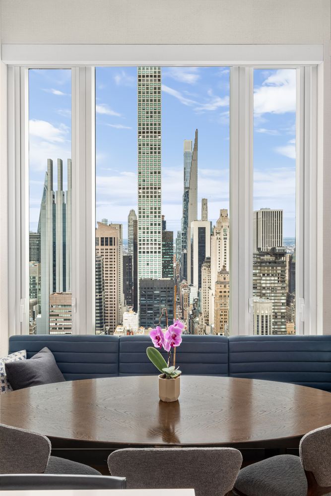 a living room with furniture and floor to ceiling windows