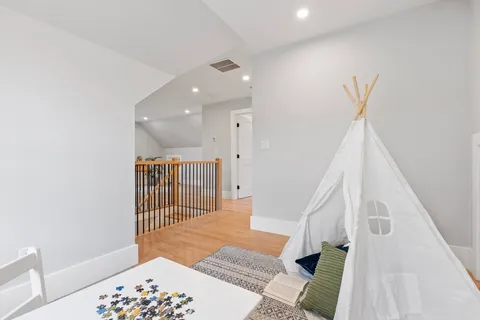 a view of a hallway with a white door and wooden floor