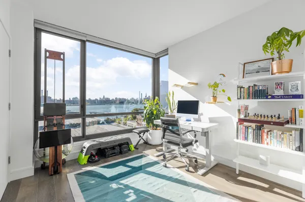 a living room with furniture a flat screen tv and a floor to ceiling window