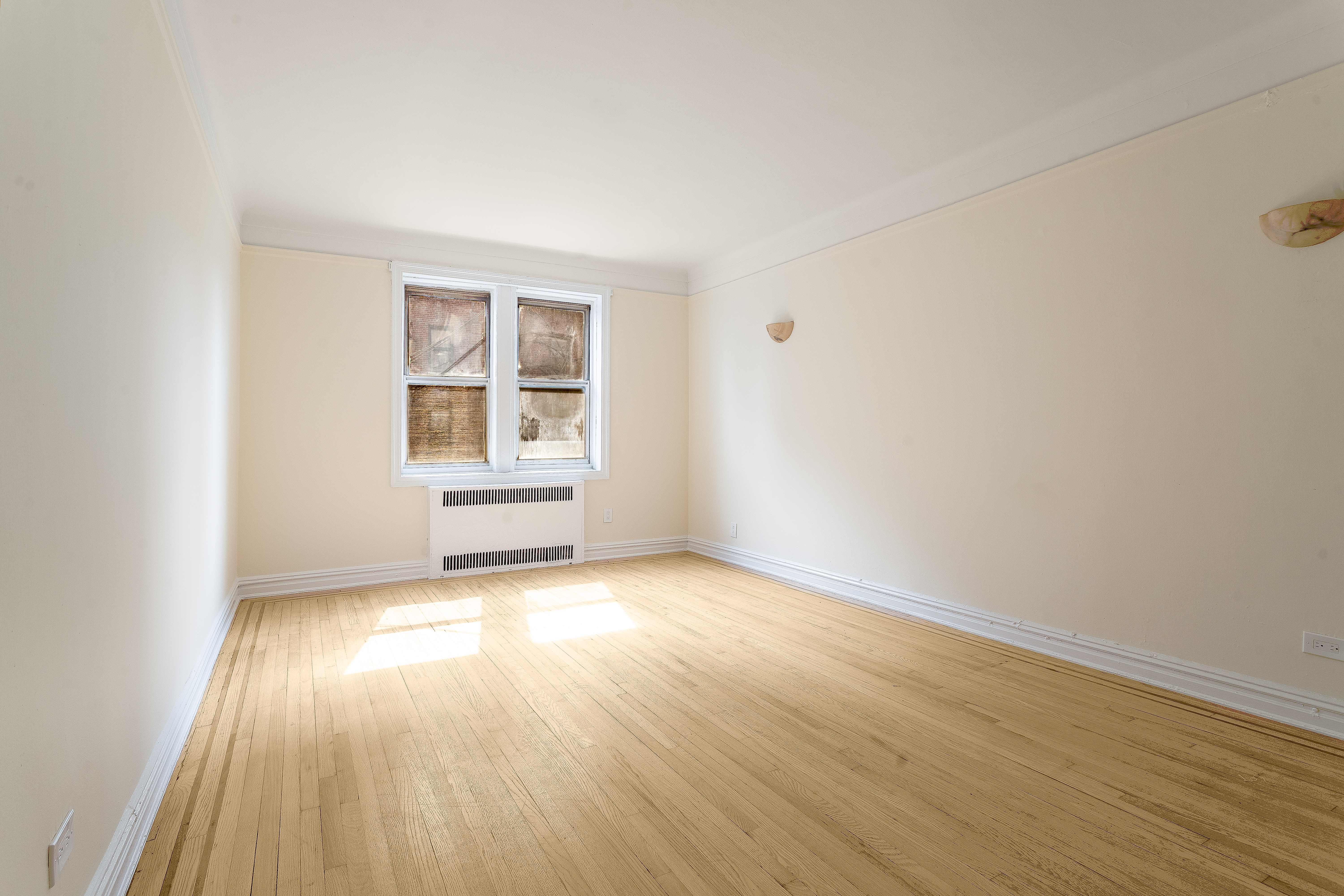 40 Tehama Street, Unit 2E Brooklyn, NY 11218 - Photo 2 of 12 an empty room with wooden floor and windows