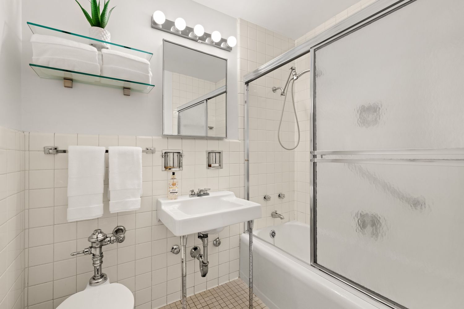 a bathroom with a sink mirror and a shower