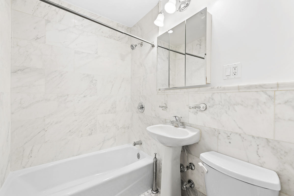 330 East 58th Street, Unit 4A Manhattan, NY 10022 - Photo 8 of 11 a bathroom with a sink a toilet and shower