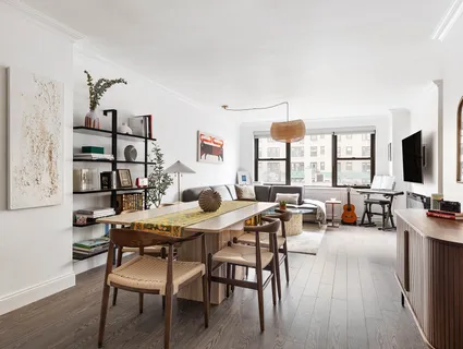 a living room with furniture flat screen tv and large windows