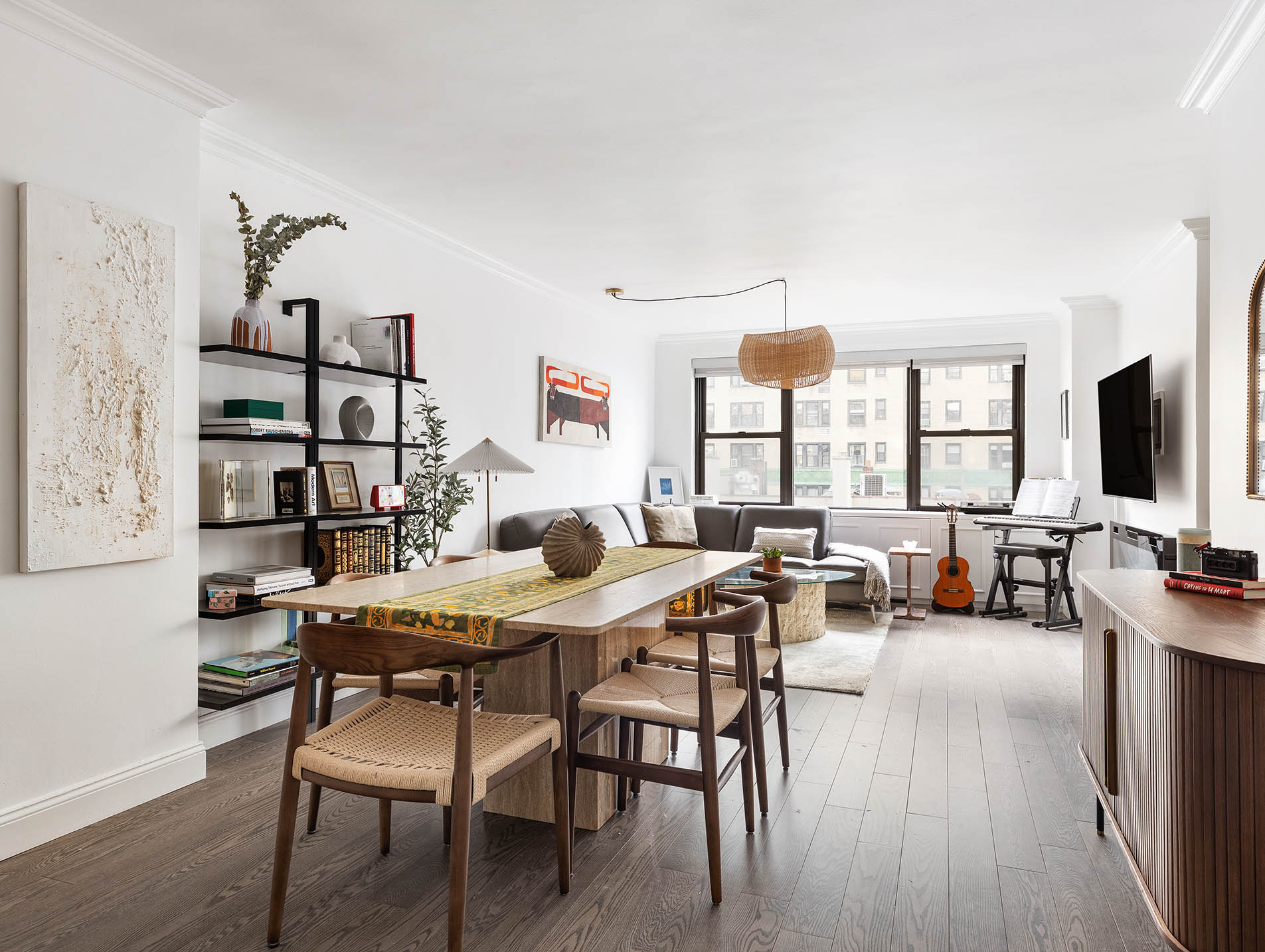 a living room with furniture flat screen tv and large windows