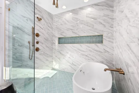 a bathroom with a white bath tub and shower
