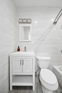 a bathroom with a toilet a sink and mirror