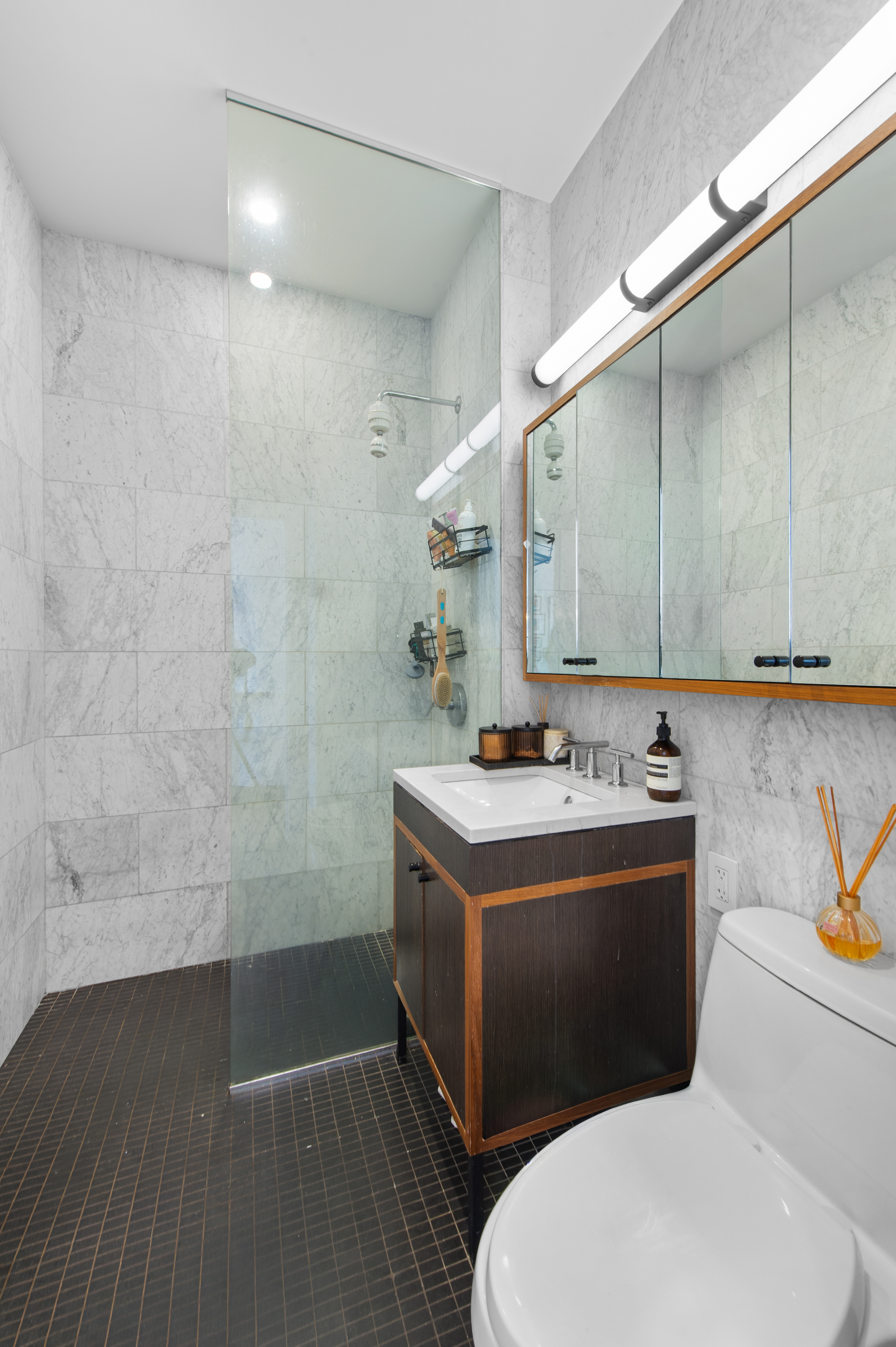 184 Kent Avenue, Unit B407 Brooklyn, NY 11249 - Photo 5 of 14 a bathroom with a sink a toilet and shower